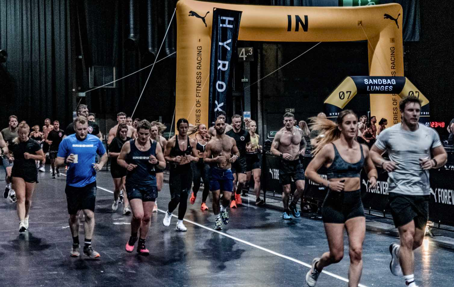 HYROX training race with athletes running between functional workout stations