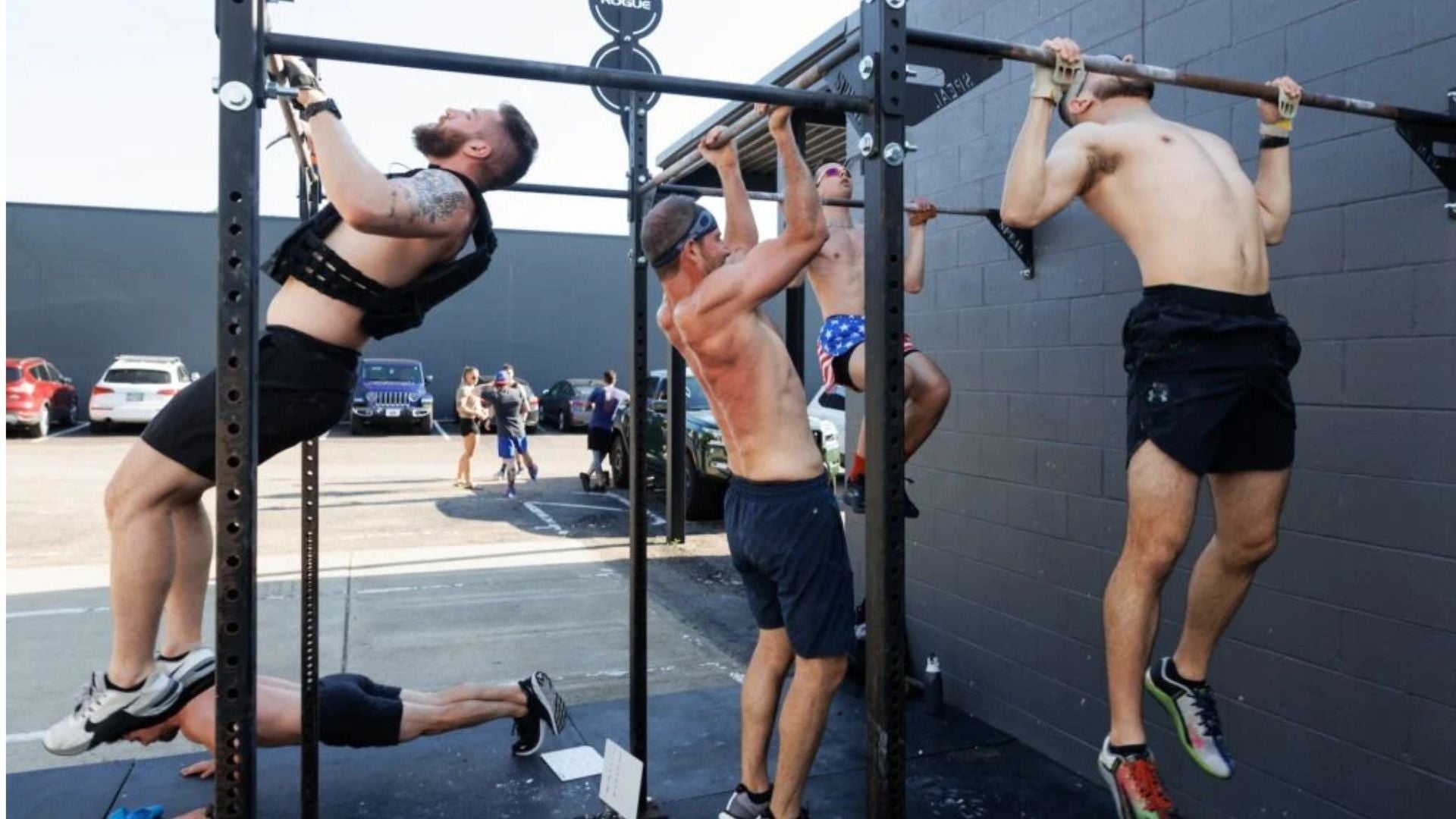 Athletes performing pull-ups as part of a 6 day gym workout schedule