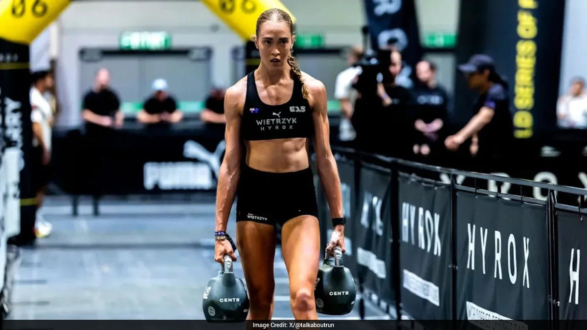 Athlete performing a farmers carry during a HYROX race workout